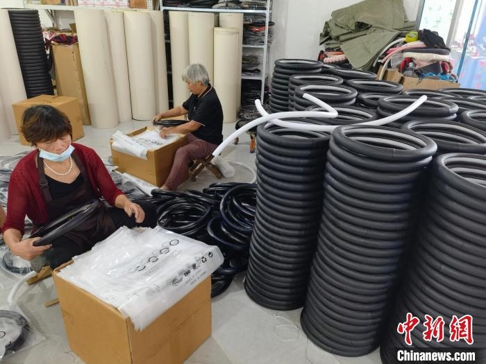 圖為村民在汽車飾品企業(yè)生產(chǎn)車間中工作?！巫雍?攝