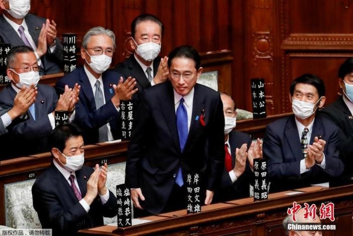 當?shù)貢r間10月4日，日本自民黨總裁岸田文雄經(jīng)過眾院全體會議的首相指名選舉成為第100任首相。圖為岸田文雄（中）起身致謝。