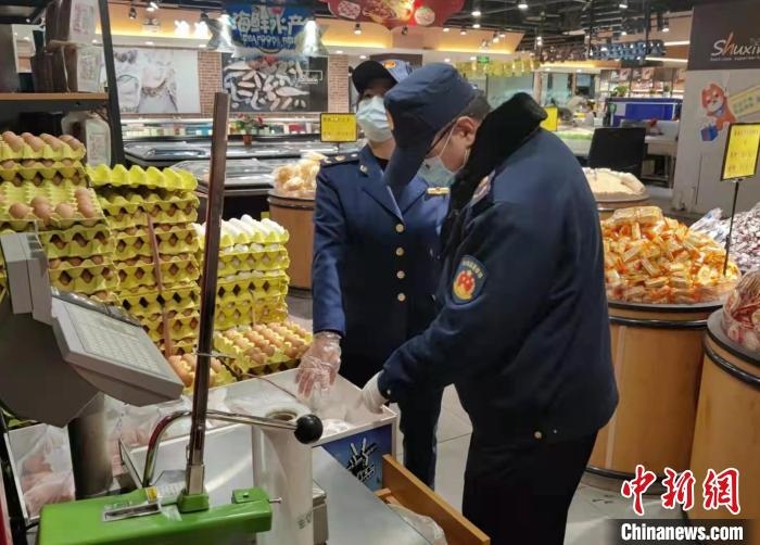 圖為疫情期間，甘肅嘉峪關(guān)市場監(jiān)管局工作人員檢查蔬菜市場。　 柴佳楠 　攝