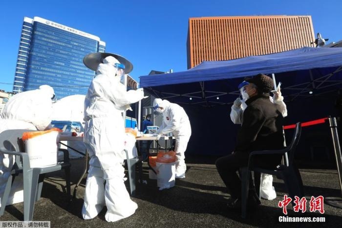 資料圖：韓國首爾，醫(yī)務(wù)人員對市民進(jìn)行新冠病毒檢測。