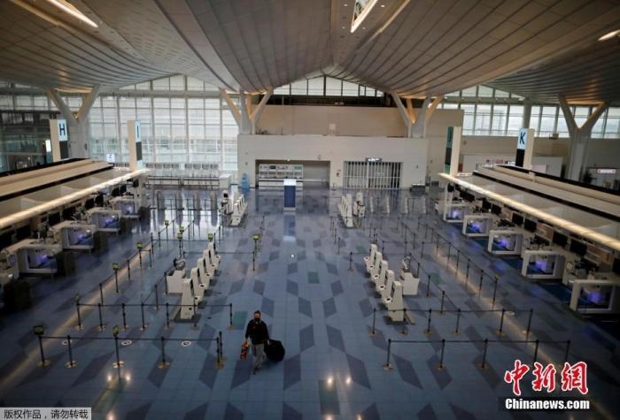 資料圖：日本東京，東京國際機場，一名乘客在國際航班航站樓的登機區(qū)。