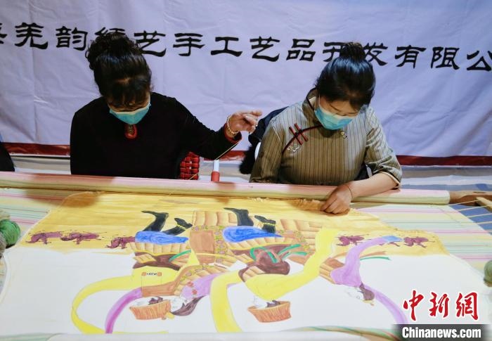 圖為皮繡藝人在市集上“秀”指尖技藝?！●R銘言 攝