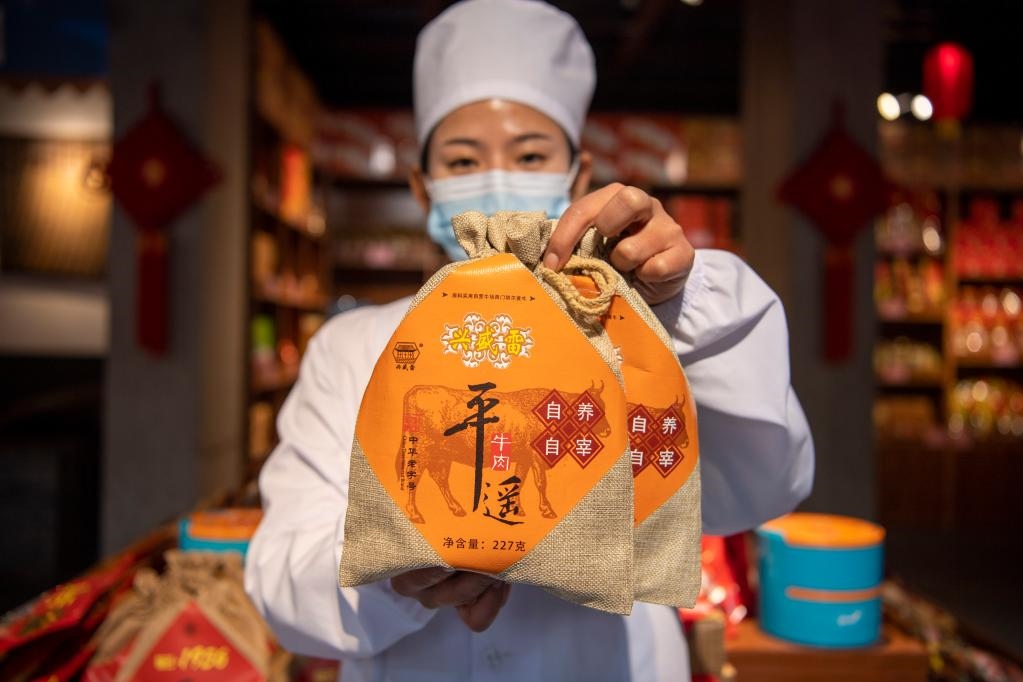 1月27日，在平遙古城南大街的一家平遙牛肉店內(nèi)，工作人員展示一款牛肉產(chǎn)品。新華社記者 楊晨光 攝