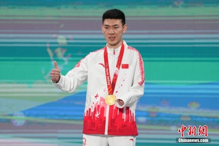3月6日，梁景怡在延慶頒獎(jiǎng)廣場(chǎng)領(lǐng)獎(jiǎng)臺(tái)上豎起大拇指。當(dāng)日，在國(guó)家高山滑雪中心舉行的北京2022年冬殘奧會(huì)殘奧高山滑雪男子超級(jí)大回轉(zhuǎn)—站姿決賽中，中國(guó)選手梁景怡奪得冠軍。 <a target='_blank' href='/'>中新社</a>記者 楊華峰 攝