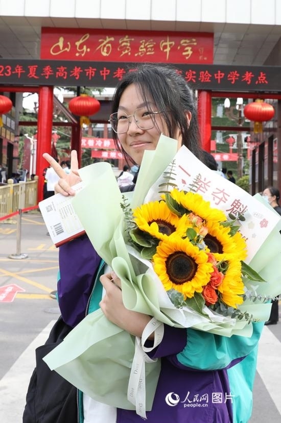 6月7日高考首日，山東67萬考生走進(jìn)考場，拼搏逐夢。在山東省實(shí)驗(yàn)中學(xué)考點(diǎn)，考生進(jìn)考場前手捧向日葵花拍照留念，寓意“一舉奪魁”。人民網(wǎng)記者 劉祺攝