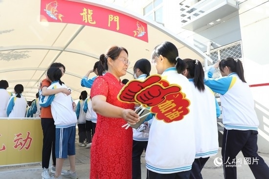 6月7日一早，雄安新區(qū)安新中學(xué)老師在給同學(xué)們加油鼓勁兒。人民網(wǎng) 李兆民攝