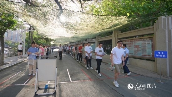 6月7日，烏魯木齊市第七十中學(xué)門口，考生們有序進(jìn)入考場。人民網(wǎng) 李欣洋攝