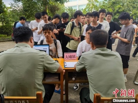 專武干部在發(fā)放兵役登記證。韋碩 攝