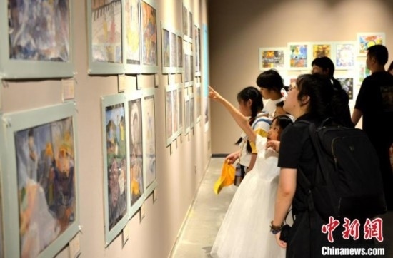 圖為家長帶著孩子參觀展覽。呂明 攝