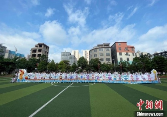 圖為學生們展示剛完成的長卷。 興業(yè)縣融媒體中心供圖