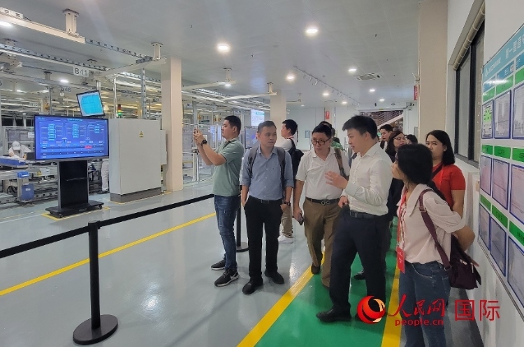 廣汽埃安工作人員向外媒記者進行介紹。人民網(wǎng) 寧玉瑛攝