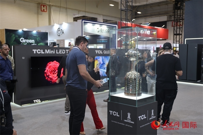 參觀者在TCL展臺(tái)前觀看南美解放者杯獎(jiǎng)杯，據(jù)介紹，TCL是南美解放者杯（2023—2026賽季）全球官方合作伙伴。（人民網(wǎng)記者 時(shí)元皓攝）