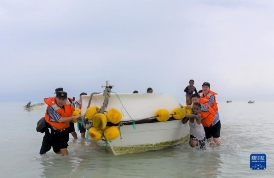 7月21日，中國海軍“和平方舟”號醫(yī)院船醫(yī)護(hù)人員涉水登島，前往基里巴斯一診療點。新華社記者 黎云 攝