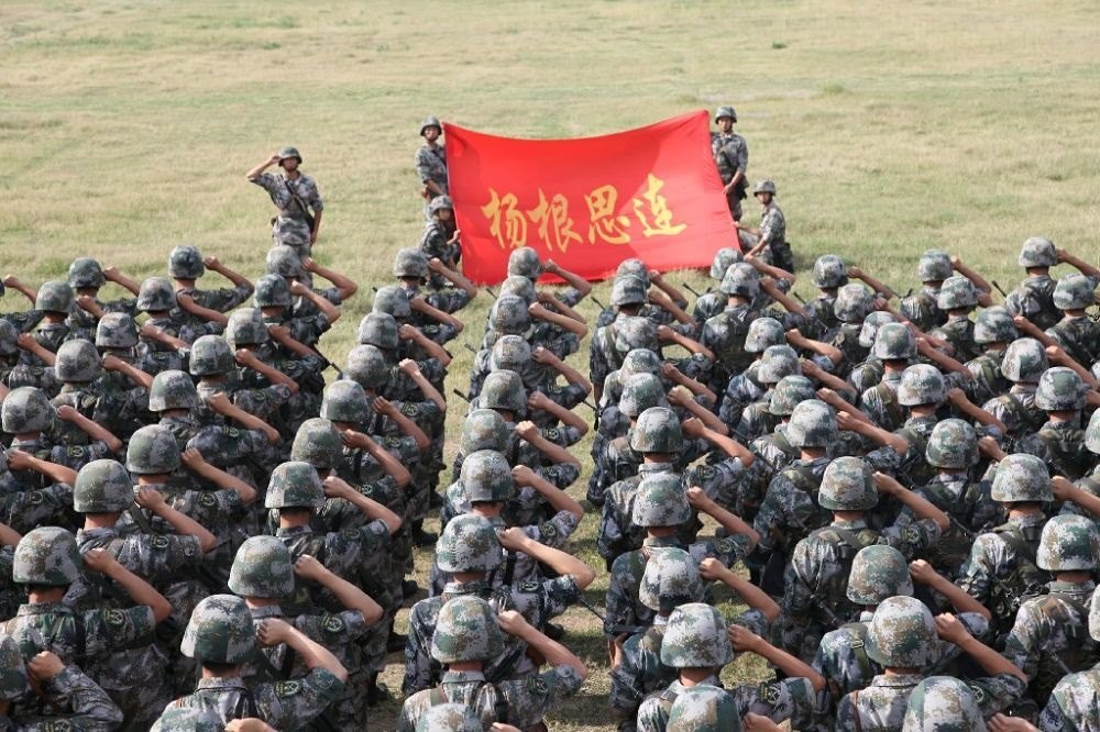 ↑“楊根思連”官兵執(zhí)行任務(wù)前向連旗宣誓（資料照片）。新華社發(fā)