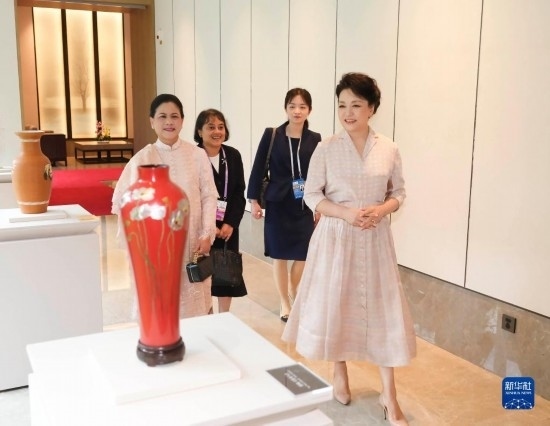 7月27日下午，國家主席習近平夫人彭麗媛在四川成都會見陪同印度尼西亞總統(tǒng)佐科來華出席第31屆世界大學生夏季運動會開幕式并訪華的總統(tǒng)夫人伊莉亞娜。這是彭麗媛和伊莉亞娜欣賞成都特色非遺工藝品。新華社記者 丁林 攝