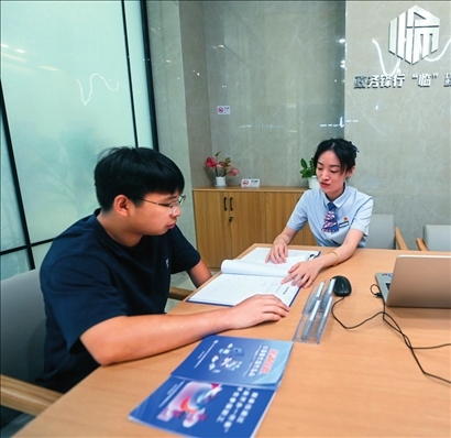 在杭州市臨安區(qū)政務服務中心的“為企服務中心”，黨員志愿者（右）解答企業(yè)主的疑問（2023年7月7日攝）。徐昱攝/本刊