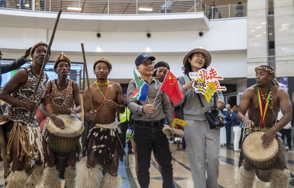 在南非約翰內(nèi)斯堡坦博國際機(jī)場，南非舞蹈演員歡迎中國試點(diǎn)恢復(fù)出境團(tuán)隊(duì)旅游后首批抵達(dá)南非的中國游客（2023年3月29日攝）。