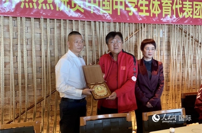 巴西中國和平統(tǒng)一促進會會長王俊曉向中國中學(xué)生體育代表團團長劉立新贈送紀念品。人民網(wǎng)記者 宋亦然攝