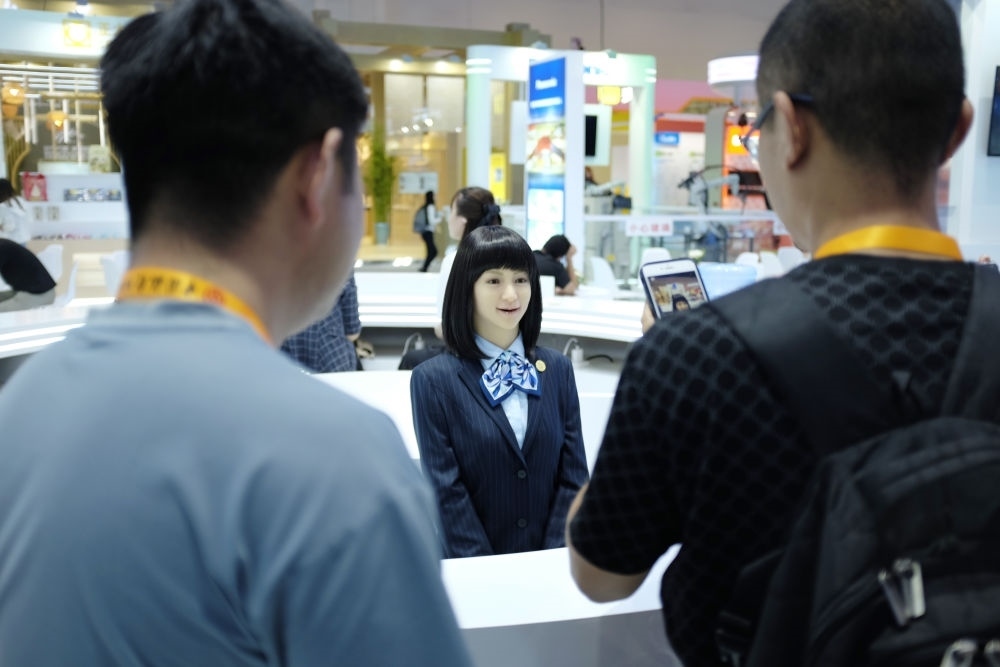 9月1日，媒體記者在國家會議中心與服務(wù)機(jī)器人互動。新華社記者 劉夢琪 攝