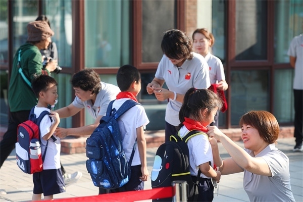8月30日，雄安史家胡同小學(xué)學(xué)生體驗(yàn)學(xué)校生活。老師為學(xué)生佩戴校徽。