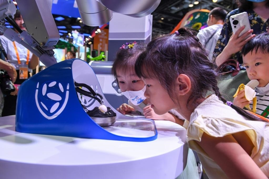 9月3日，幾名小朋友在國(guó)家會(huì)議中心觀看單孔腔鏡手術(shù)機(jī)器人展示。新華社記者 鞠煥宗 攝