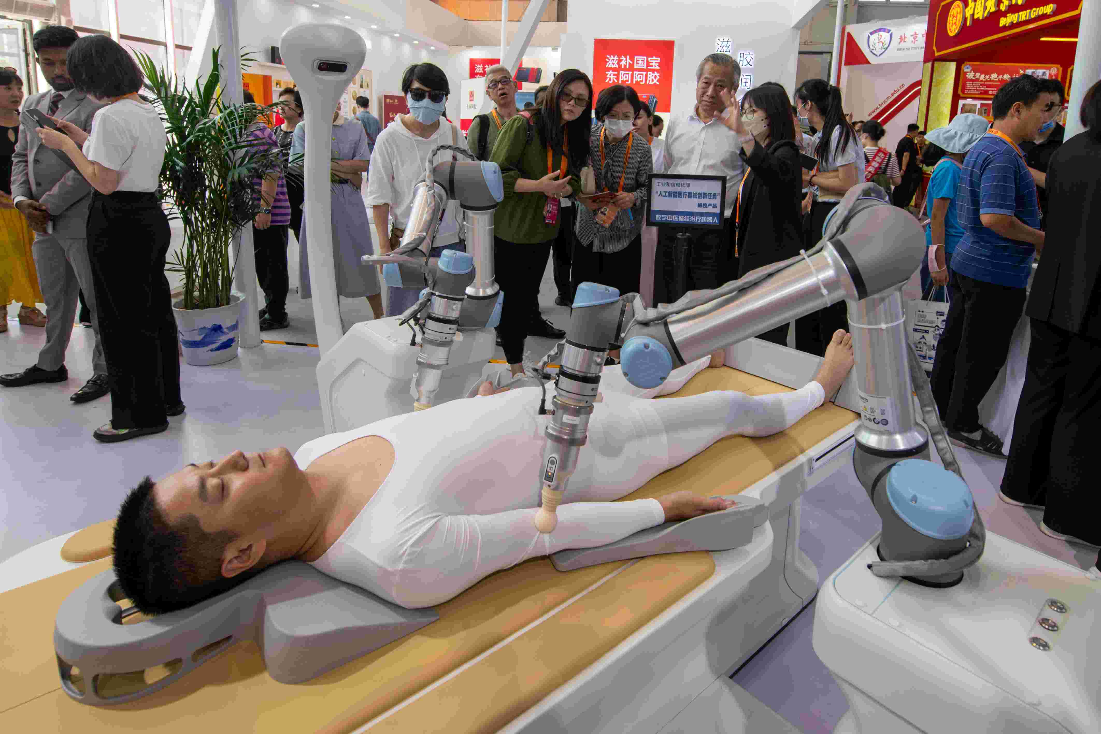 在位于首鋼園的健康衛(wèi)生服務(wù)展區(qū)，觀眾正在參觀數(shù)字中醫(yī)循經(jīng)治療機(jī)器人。人民網(wǎng)記者 翁奇羽攝