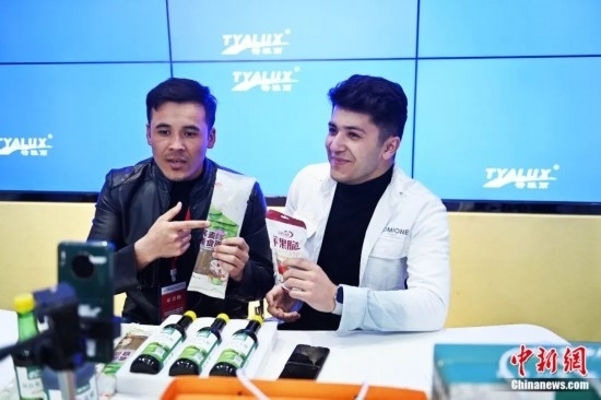 2023年3月，甘肅省慶陽市環(huán)縣電商創(chuàng)業(yè)孵化基地內(nèi)，來自蘭州文理學(xué)院的塔吉克斯坦留學(xué)生正在協(xié)助主播直播帶貨當(dāng)?shù)剞r(nóng)特產(chǎn)品。李亞龍 攝