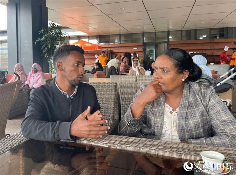 約漢斯（圖左）與德貝拉在友誼廣場(chǎng)咖啡廳交談。人民網(wǎng)記者 趙艷紅攝