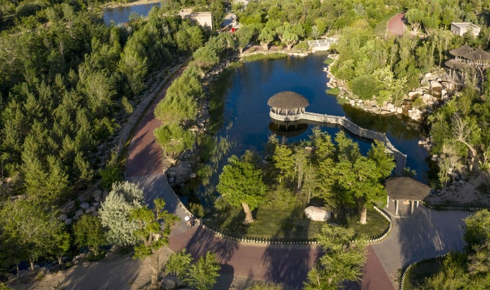 坐落在寧夏銀川市賀蘭山腳下的賀蘭山運(yùn)動休閑公園（2021年5月27日攝，無人機(jī)照片）。這里曾是一片砂石采礦塌陷區(qū)，當(dāng)?shù)赝ㄟ^植被景觀再造、水系建設(shè)、現(xiàn)代管網(wǎng)鋪建等手段，重新利用廢石、廢坑及各類廢棄建筑材料，把這里變成一座免費(fèi)開放的主題公園。新華社記者 馮開華 攝
