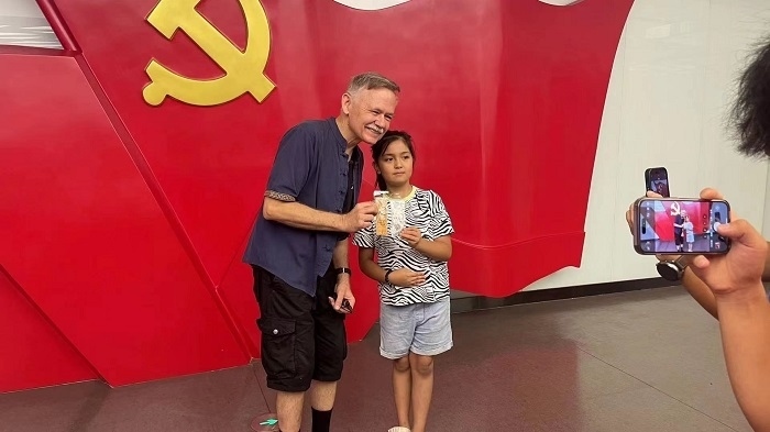 潘維廉和志愿講解員紀(jì)念合影。主辦方供圖