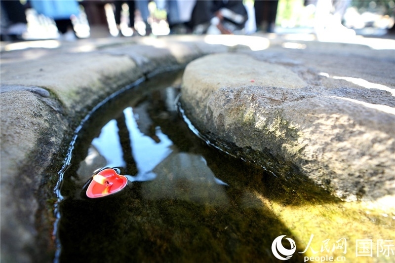圖為水渠里流過的“桃心”蠟燭。人民網(wǎng) 盧鵬宇攝