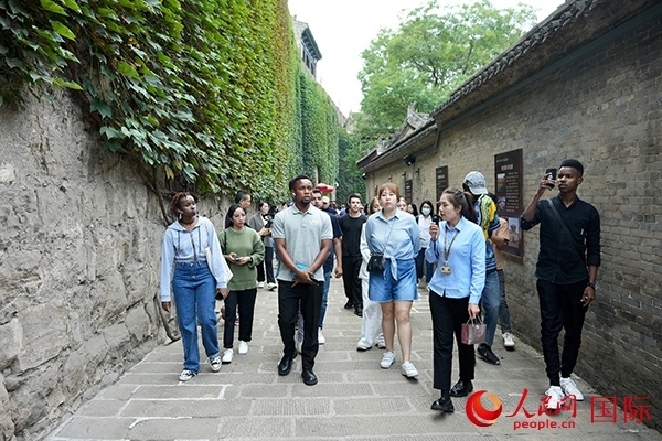 選手們認真聆聽導游講解。人民網(wǎng) 盧鵬宇攝