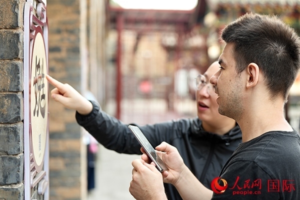 選手安德烈（俄羅斯）在老師指導下學習墻壁上張貼的生僻字。人民網(wǎng) 盧鵬宇攝