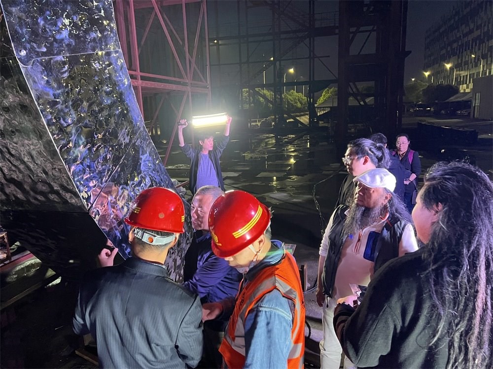 林崗（右二）和團隊查看主火炬制作進度。受訪者供圖