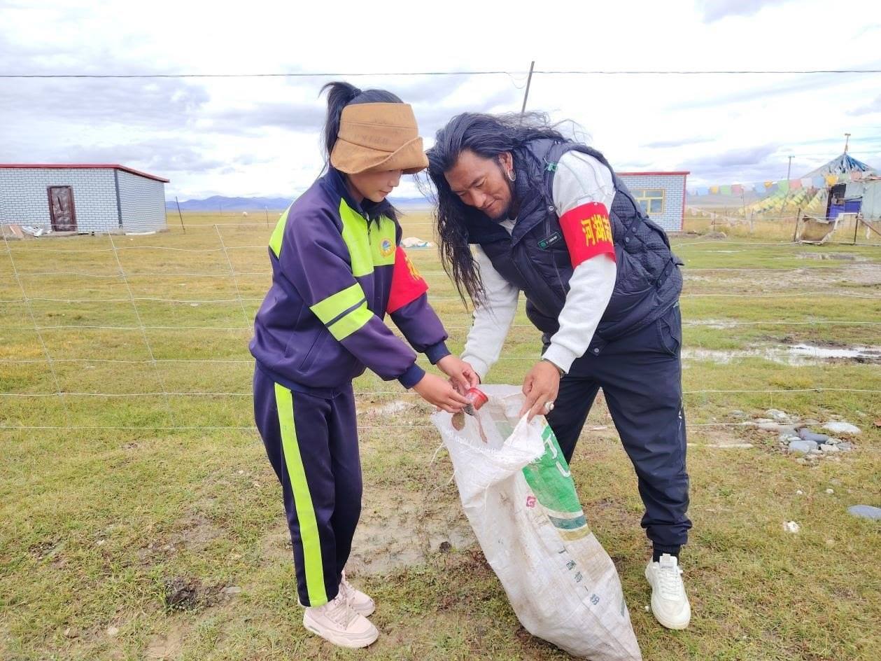玉樹州稱多縣珍秦鎮(zhèn)河湖志愿者才培和他女兒更求拉毛在清掃垃圾。受訪者供圖