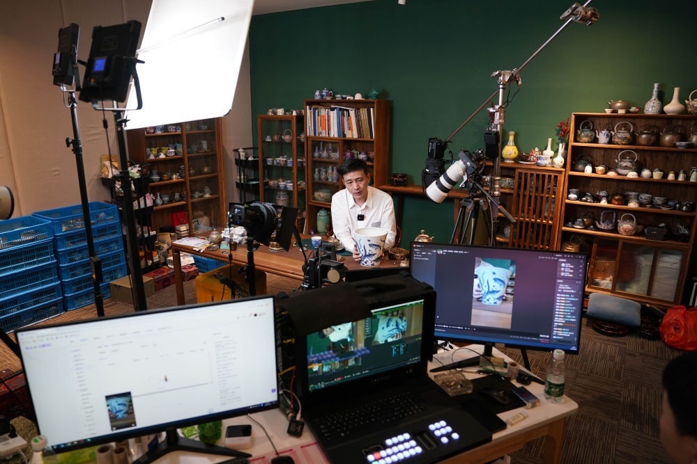 ↑在景德鎮(zhèn)，工作人員通過網絡直播推介陶瓷產品（2023年2月22日攝）。
