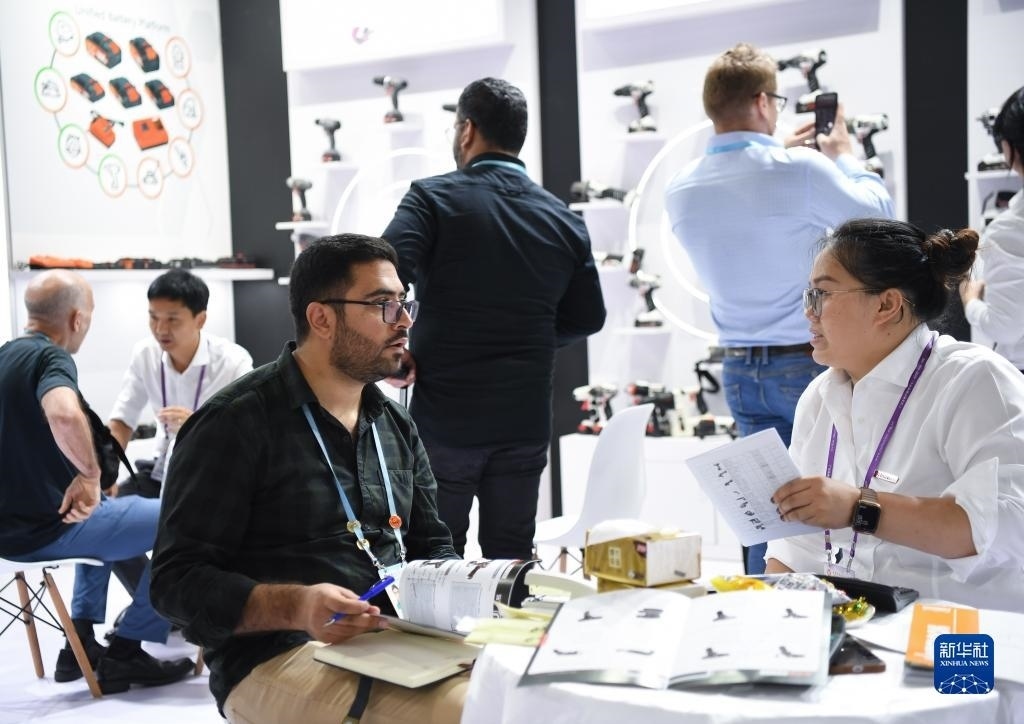 10月15日，在一家電動工具展臺，外國采購商在洽談業(yè)務。新華社記者 鄧華 攝