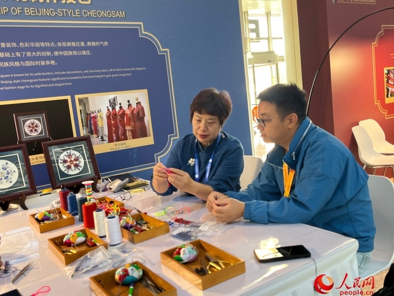 記者在新聞中心非遺傳承人展區(qū)進(jìn)行體驗(yàn)。人民網(wǎng)記者 杜燕飛攝