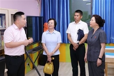 圖③：“小公民法律課堂”開講前，全國人大代表殷其龍（右二）、重慶市人大代表李自玲（左二）聽取楊家坪中學(xué)負(fù)責(zé)人關(guān)于未成年人思想教育工作情況的介紹。