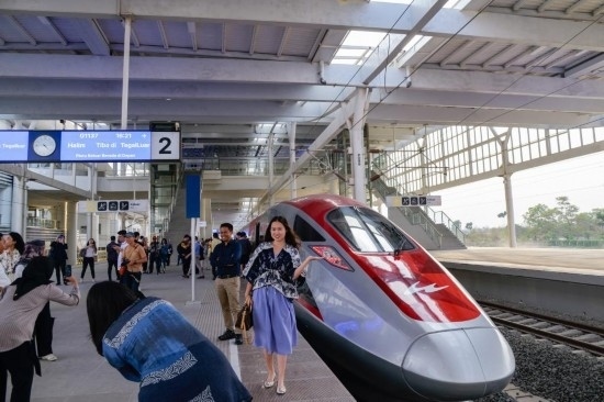  10月17日，在印度尼西亞萬(wàn)隆德卡魯爾站，乘客在站臺(tái)上和雅萬(wàn)高鐵高速動(dòng)車(chē)組列車(chē)合影。新華社記者 徐欽 攝