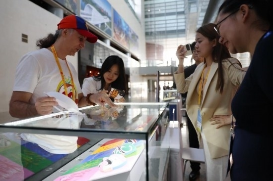 10月16日，參會(huì)記者在“一帶一路”國(guó)際合作高峰論壇新聞中心參觀展示的中國(guó)非物質(zhì)文化遺產(chǎn)展品。新華社記者 陳斌 攝