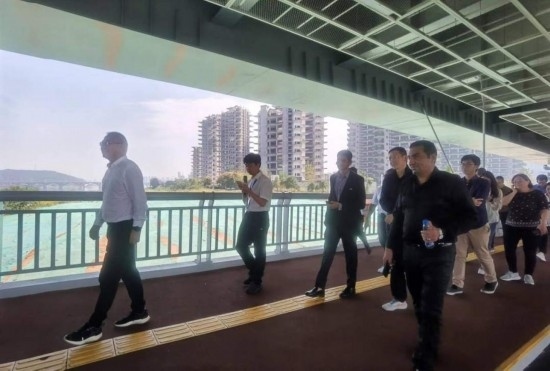 10月24日，2023“一帶一路”媒體合作論壇聯(lián)合采訪團(tuán)團(tuán)員走在清水塘大橋景觀通道上。本報記者 常雯宜攝