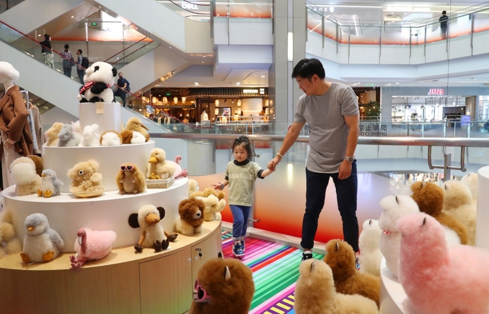 2023年11月2日，顧客在溫暖駝品牌專柜內(nèi)選購。連續(xù)六年參加進博會的秘魯羊駝制品品牌溫暖駝在上海市中心商場開設(shè)了專柜。新華社記者 方喆 攝