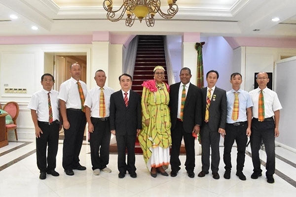 多米尼克總統(tǒng)伯頓和駐多米尼克大使林先江與中國農業(yè)技術專家組合影。中國駐多米尼克大使館供圖