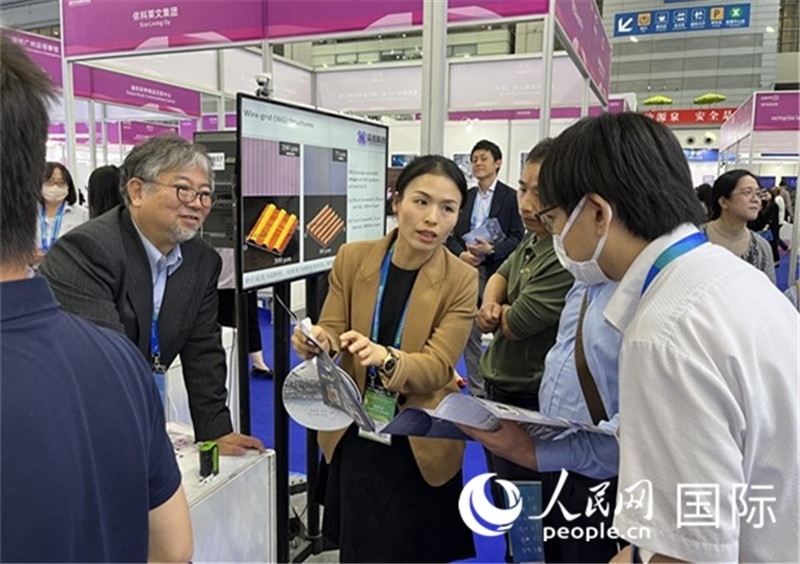 工作人員向參觀者介紹超級(jí)噴墨技術(shù)。（人民網(wǎng)記者 陳思攝）