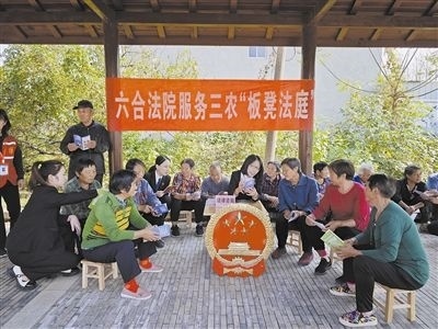  圖③：干警向附近農(nóng)戶解讀相關法律法規(guī)。