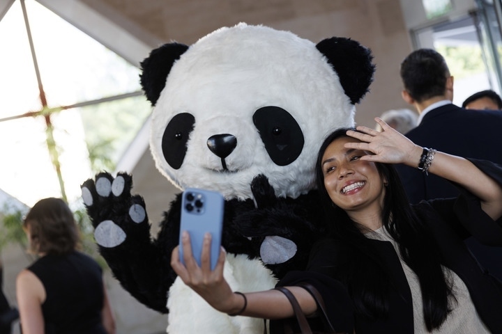 2022年8月24日，在美國華盛頓中國駐美國大使館，來賓與大熊貓玩偶合影。
