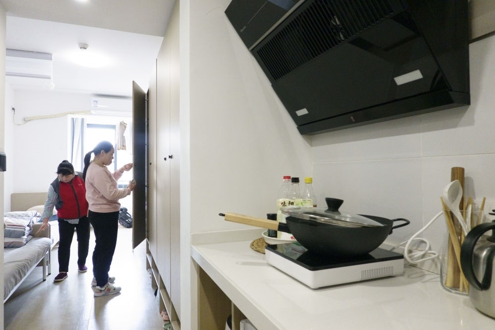 住戶在閔行區(qū)新時代城市建設者管理者之家收拾房間。