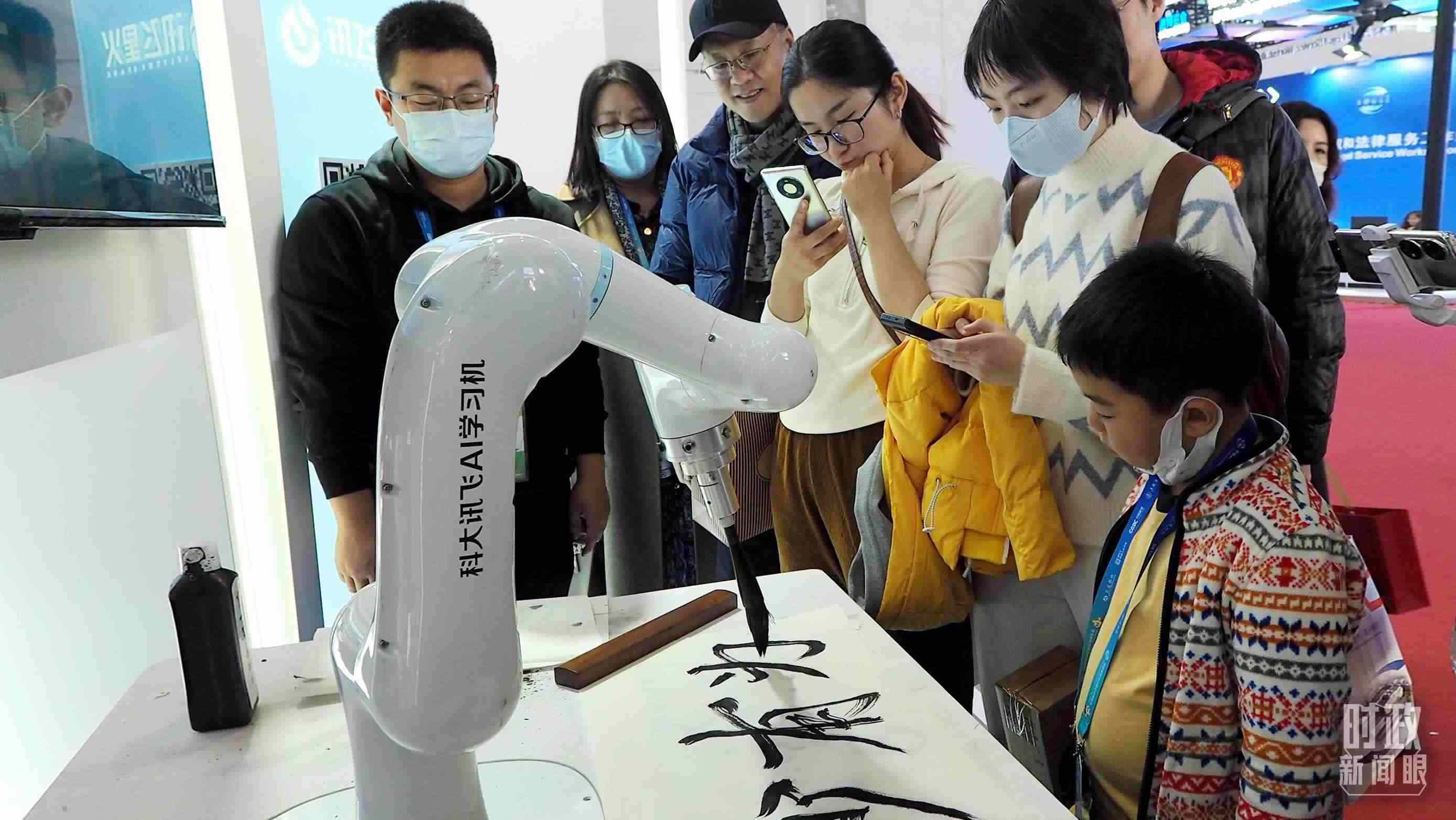 △觀眾在首屆鏈博會上體驗(yàn)AI書法機(jī)器人。