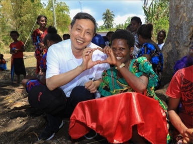 2023年12月18日，中國駐瓦努阿圖大使李名剛和前來觀看瓦努阿圖公路項目二期馬勒庫拉段移交儀式的當(dāng)?shù)鼐用窈嫌?。人民網(wǎng) 賀吉攝